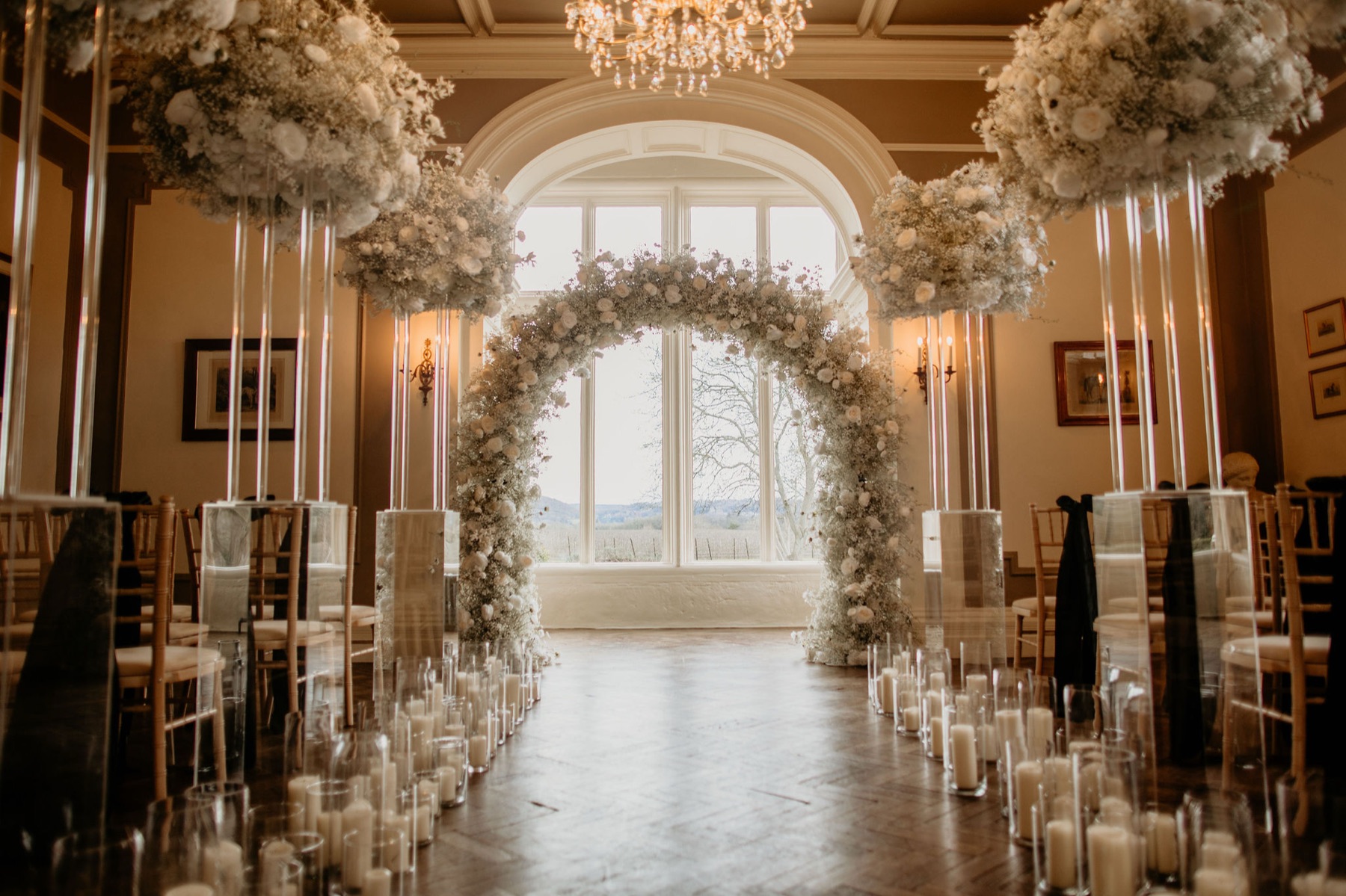The ceremony room dressed with a floral arch and candlelight
